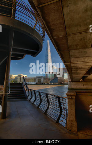 Der Shard London durch die Lücke zwischen der London Bridge und der pedestian Treppe vom North Bank Spaziergang auf der Brücke aus gesehen Stockfoto