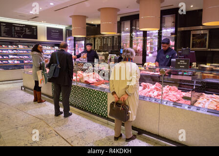 Kunden kaufen Fleisch Metzgerei von La Grande Épicerie De Paris, Paris, Frankreich Stockfoto