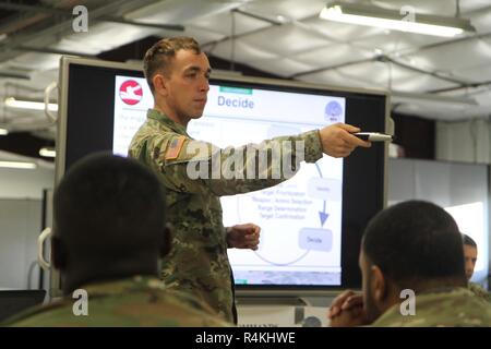U.S. Army Reserve Task Force Dagger Kader Mitglied Sgt. Matthäus Bacca beauftragt die Erste Kreide der rotierenden Einheit Soldaten am virtuellen Kampf Platz 3 (VBS 3) Schießwesen Trainer Plug-In-Klasse während des Betriebs Cold Steel III, bewirtet durch die US-Armee die zivilen Angelegenheiten und psychologische Funktion Befehl an Joint Base Mc Guire-Dix - Lakehurst, New Jersey, Okt. 30, 2018. Mit Hilfe dieser Simulation, die Fahrzeugbesatzung Evaluator ist in der Lage, das Fahrzeug Commander (VC) und Gunner auf individueller und Crew - die koordinativen Fähigkeiten, Engagement Techniken zu vermitteln, und gezielte Akquisition. Betrieb Cold Steel ist der USA. Stockfoto