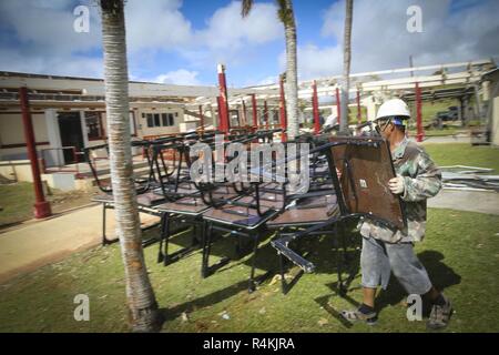 Ein Saipan öffentlichen Arbeitnehmer nimmt Schreibtische von Innen von Saipan Volkshochschule nach Super Typhoon Yutu, November 2, 2018. Super Typhoon Yutu war der stärkste Wirbelsturm über Saipan und Tinian in der Nördlichen Marianen. Stockfoto