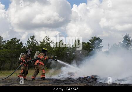 96. Test Wing Feuerwehrmänner Schlacht Feuer um eine simulierte Hubschrauberabsturz während einer Messe Unfallversicherung Übung 3 in Eglin Air Force Base, Fla. Die gemeinschaftsweite übung tief in den Eglin Bereich umfasste 96 TW Ersthelfer, 6 Ranger Training Bataillon Personal, Okaloosa County Ersthelfer unter anderem. Die übung ausgewertet Ranger Aktionen und Base und lokale Antworten auf beide ein Blitzschlag und Absturz eines Hubschraubers. Stockfoto