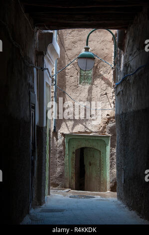 18-04-11 Marrakesch, Marokko. In der Medina, ein Blick hinunter eine Lampe Alley, einer alten Tür-/Eingang eines Hauses beleuchtet. Foto © Simon Grosset Stockfoto