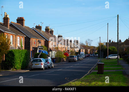 Suburban Szene mit Straße und Autos geparkt und Grünstreifen in Lingfield, Surrey, Großbritannien Stockfoto