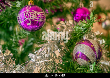 Lila Ornamente hing an einem Weihnachtsbaum Stockfoto