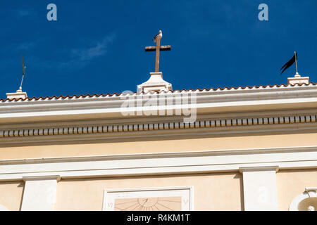 Obere vordere Fassade Detail, Santa Maria Maddalena Kirche mit Sonnenuhr und Kreuz gegen einen blauen Himmel; die Kirche Santa Maria Maddalena, La Madellena, Sardinien Stockfoto