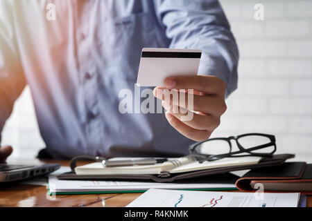 Unternehmer, die Kreditkarte und mit Laptop. Die Zahlung beim Online shopping. E-Commerce und moderne Technik Konzept Stockfoto