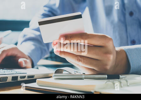 Unternehmer, die Kreditkarte und mit Laptop. Die Zahlung beim Online shopping. E-Commerce und moderne Technik Konzept Stockfoto