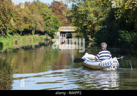 Mann in einem Sea Eagle SE-370 aufblasbare Kajak auf dem Chichester Kanal im Herbst in West Sussex, England, UK. Mann Kajak fahren. Stockfoto