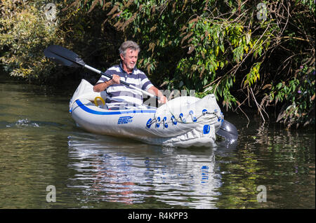 Im mittleren Alter Mann Paddeln mit einem länglichen Platte in einem Sea Eagle SE-370 aufblasbare Kajak, an einem Kanal in Großbritannien. Stockfoto