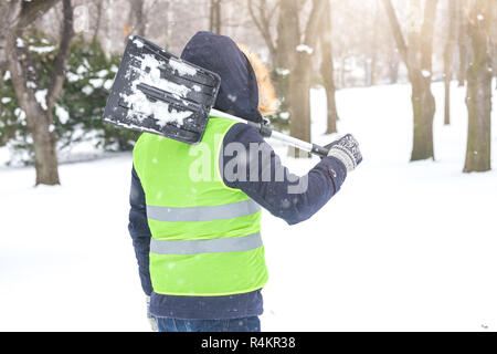 Ansicht der Rückseite des Mann hält Schaufel über seine Schulter und Vorbereitung der Schneeschaufeln. Stockfoto