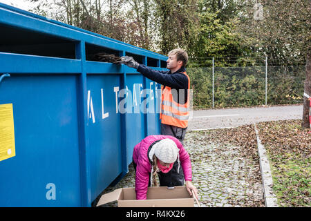 Frau und Mann das Altpapier in Container Recycling center Stockfoto