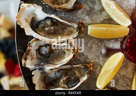 Austern in Eis, mit Soße und Zitrone. Restaurant ernähren. closeup Stockfoto