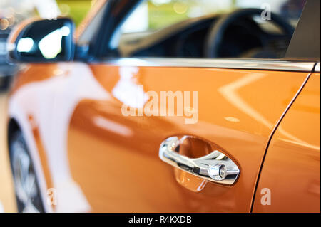 Chrome metallische Griff der neuen orange Auto closeup. auto Autohaus Stockfoto