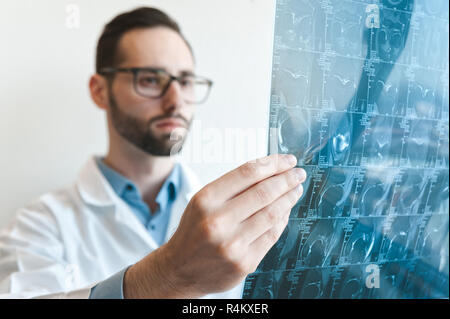 Junge Arzt bei der Magnetresonanztomographie Schuß des Kniegelenk suchen. Meniskus Verletzungen. verschwommen Stockfoto