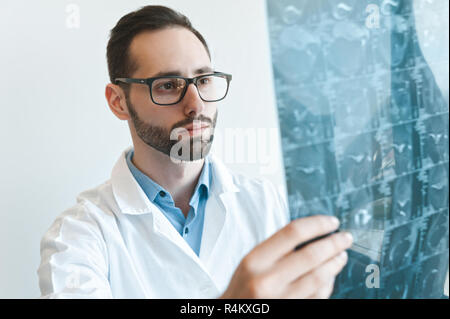 Junge Arzt bei der Magnetresonanztomographie Schuß des Kniegelenk suchen. Meniskus Verletzungen mrt Röntgen Stockfoto