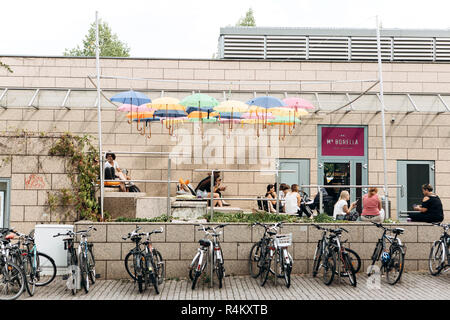 Deutschland, Leipzig, September 6, 2018: Kreative cafe in Leipzig. Viele bunte Sonnenschirme hängen Overhead. Menschen entspannen, plaudern und Essen Stockfoto