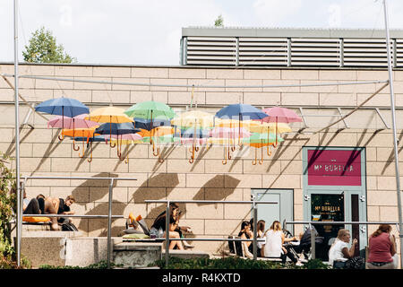 Deutschland, Leipzig, September 6, 2018: Kreative cafe in Leipzig. Viele bunte Sonnenschirme hängen Overhead. Menschen entspannen, plaudern und Essen Stockfoto