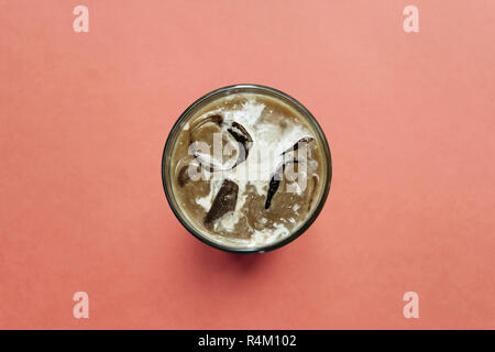 Ansicht von oben Close-up auf aromatische Frische Eiskaffee auf einem roten Hintergrund. Morgen erfrischenden alkoholfreien Getränk. Stockfoto