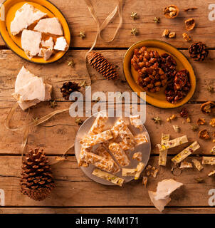 Nougat und Weihnachtsschmuck auf einem Holztisch. Stockfoto