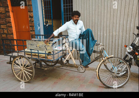 Indische Rikscha Mann sitzt auf seinem Fahrzeug, 23. Februar 2018 Madurai, Indien Stockfoto