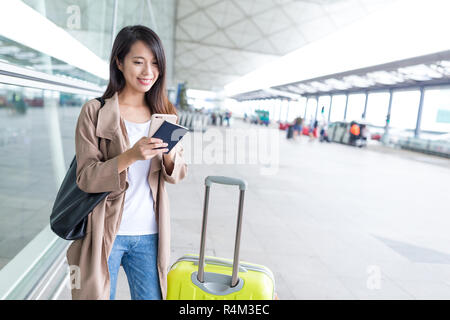 Reisen Frau mit Handy mit Gepäck Stockfoto