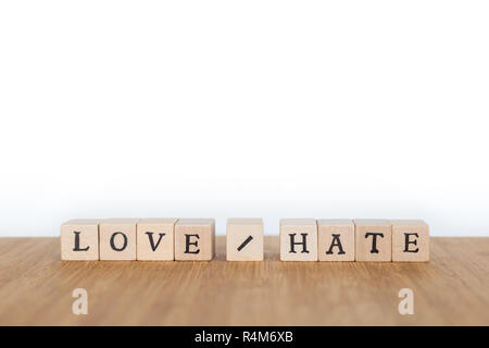 Konzentrieren Sie sich auf die Worte "Love/Hate' aus Holz Würfel mit Buchstaben auf einem Holztisch. Geringe Tiefenschärfe. Kopieren Sie Platz. Stockfoto