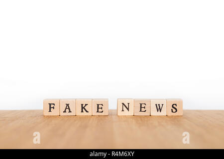 Fokus auf die Phrase 'Fake News' aus Holz Würfel mit Buchstaben auf einem Holztisch. Geringe Tiefenschärfe. Kopieren Sie Platz. Stockfoto