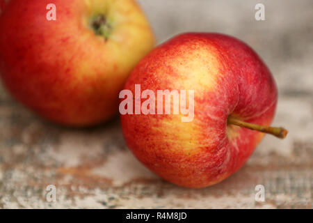 Zwei rote Äpfel auf einem alten Küchentisch Stockfoto