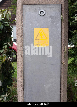 Gefahr! Stromführende Drähte gelb und schwarz Not Warnschild auf der Metallplatte und konkrete außerhalb Stockfoto