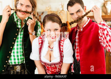 Junge Leute, die sich für traditionelle bayerische Tracht im Restaurant oder im Pub Stockfoto