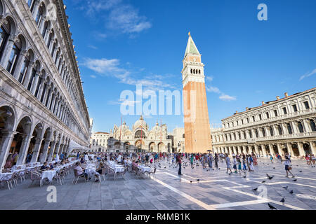 Venedig, Italien, 12. AUGUST 2017: San Marco Platz mit Bürgersteig Tabelle und Menschen zu Fuß, blauer Himmel an einem sonnigen Sommertag in Italien Stockfoto