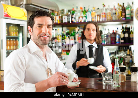 Barista mit Client in seinem Cafe oder Coffeeshop Stockfoto