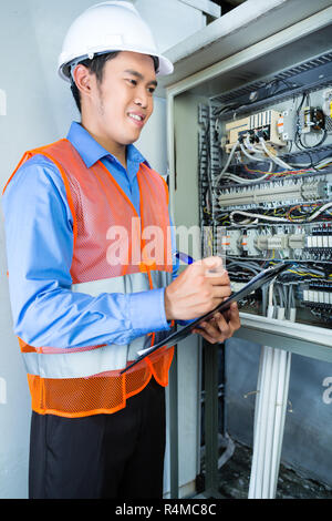 Asiatische Elektriker im Panel auf der Baustelle Stockfoto