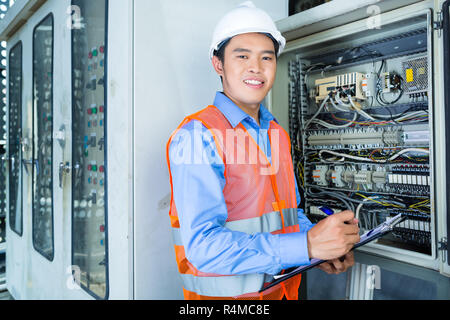 Asiatische Elektriker im Panel auf der Baustelle Stockfoto