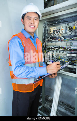 Asiatische Elektriker im Panel auf der Baustelle Stockfoto