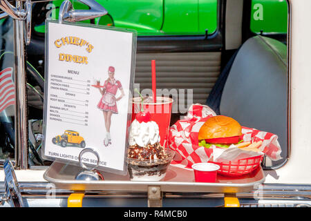 1950er Preise für Kunststoff Nachbildungen von Auto-hop Essen auf der Fahrerseite Tür Serviertablett ein Fenster Fach auf eine Chevrolet 1954 schmücken, erinnern an eine längst vergangene Ära bei einem Oldtimertreffen in Huntington Beach, CA. Stockfoto