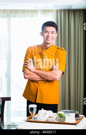 Asiatische Chinese Room service Kellner Servieren von Speisen im Hotel Suite Stockfoto