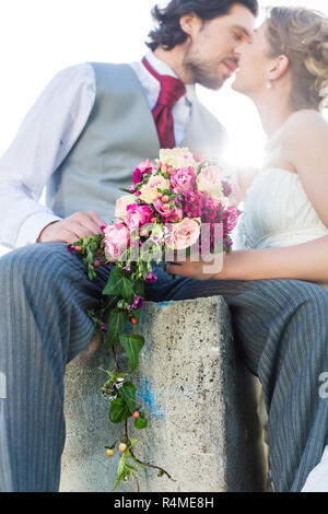 Brautpaar küssen auf Feld nach Hochzeit Stockfoto