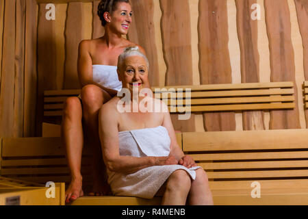 Senior und junge Frau in der Sauna Schwitzen in der Hitze Stockfoto
