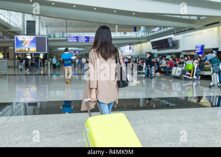 Ansicht der Rückseite Frau wandern mit Gepäck in Hong Kong International Airport Stockfoto