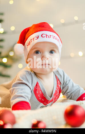 Frohe Weihnachten Baby Mädchen in ein Kästchen um Weihnachtsbaum und Dekorationen Stockfoto