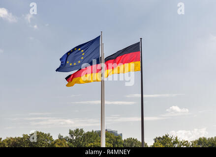 Deutsche und Europäische Union Flaggen Streaming auf fahnenmasten gegen Himmel Hintergrund in Berlin, Deutschland. Stockfoto