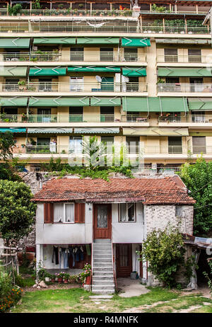 Kleine Gebäude unterhalb der Wohnblock Thessaloniki, Griechenland in den Schatten gestellt. Stockfoto