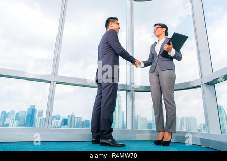 Asiatischen Geschäftspartnern Hände schütteln Stockfoto