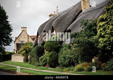 Traditionelle Cotswolds Stein Reetdachhäuser Stockfoto