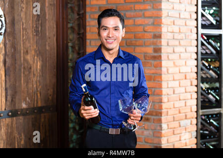 Asiatischer Mann mit Flasche Wein Stockfoto