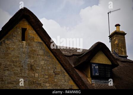 Dach Linie der traditionellen Cotswolds Stein Reetdachhäuser Stockfoto