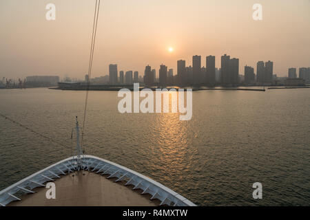 Sonne hinter der hohen Skyline von Qingdao in China. Stockfoto