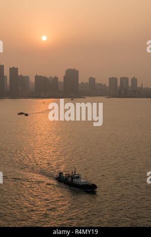 Sonne hinter der hohen Skyline von Qingdao in China. Stockfoto