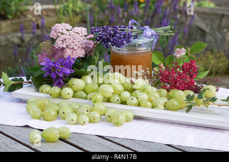 Sommer Ambiente mit stachelbeeren auf Holz Fach liebevoll mit Blumen und Jam jar eingerichtet Stockfoto